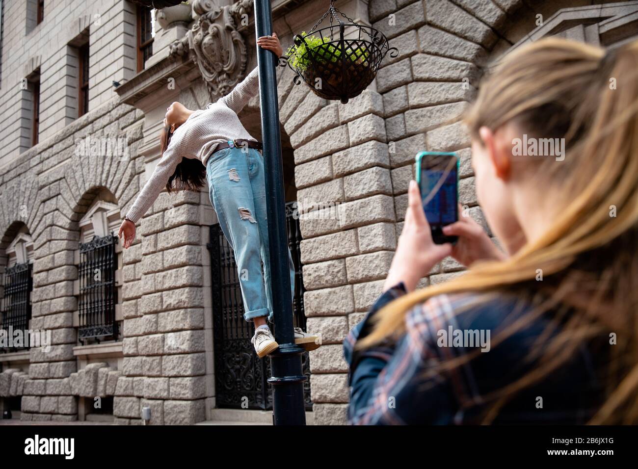 Vista posteriore della ragazza che prende il suo amico in foto Foto Stock