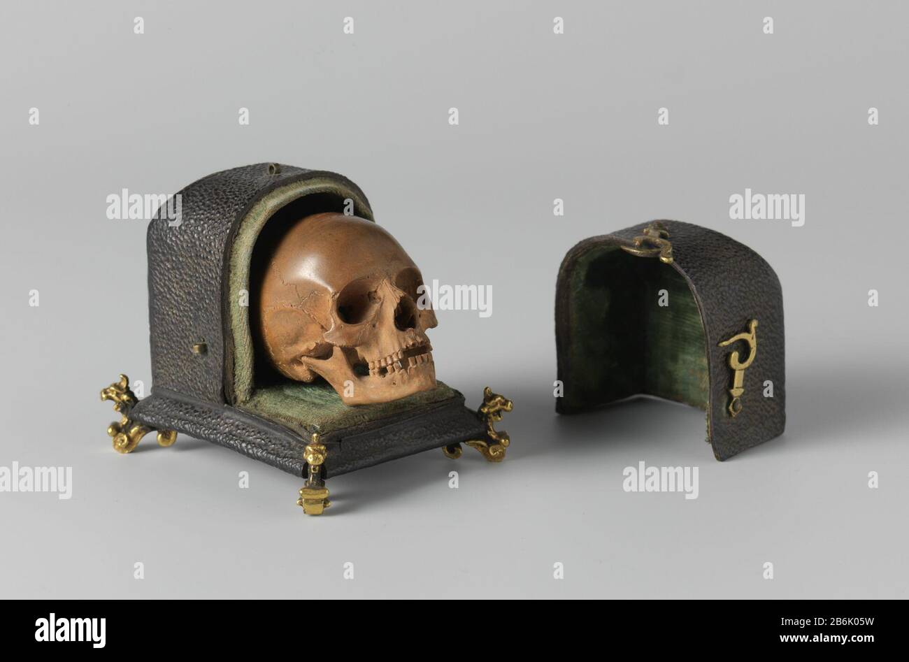 Cranio e cranio caso con caso memento mori Het doodshoofd è natuurgetrouw weergegeven. Het etui, overtrokken met segrijnleer, è van binnen met groen fluweel bekleed. Het Rust op vier verguld koperen griffioenen en wordt ha incontrato drie koperen haakjes gesloten. Produttore : Beeldhouder: Albert Jansz. VinckenbrinckPlats manufacture: Amsterdam Dating: CA. 1650 kenmerken Fisici: Palkhout (buxus), segrijnleer en koper Materiale: Palmhout koper verguldsel segrijn Techniek: Vergulden dimensioni: Schedel: H 4 cm. ETUI: H 6,5 cm. × b 6 cm. × d 7 cm. Oggetto: Cranio (umano) Foto Stock