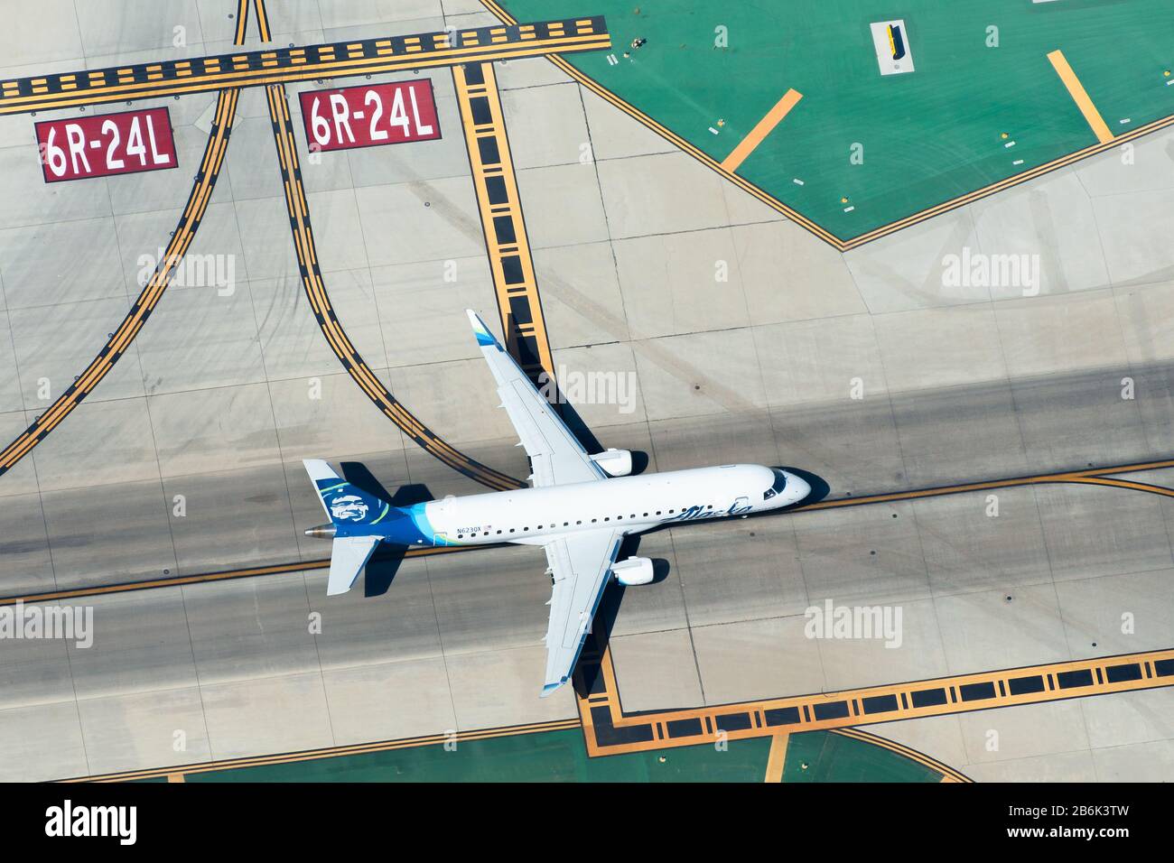 Vista aerea di Alaska Airlines Embraer 175 gestito da Horizon Air all'aeroporto LAX / KLAX. Marcature di pista e di taxiway per il modello di traffico sul tarmac. Foto Stock