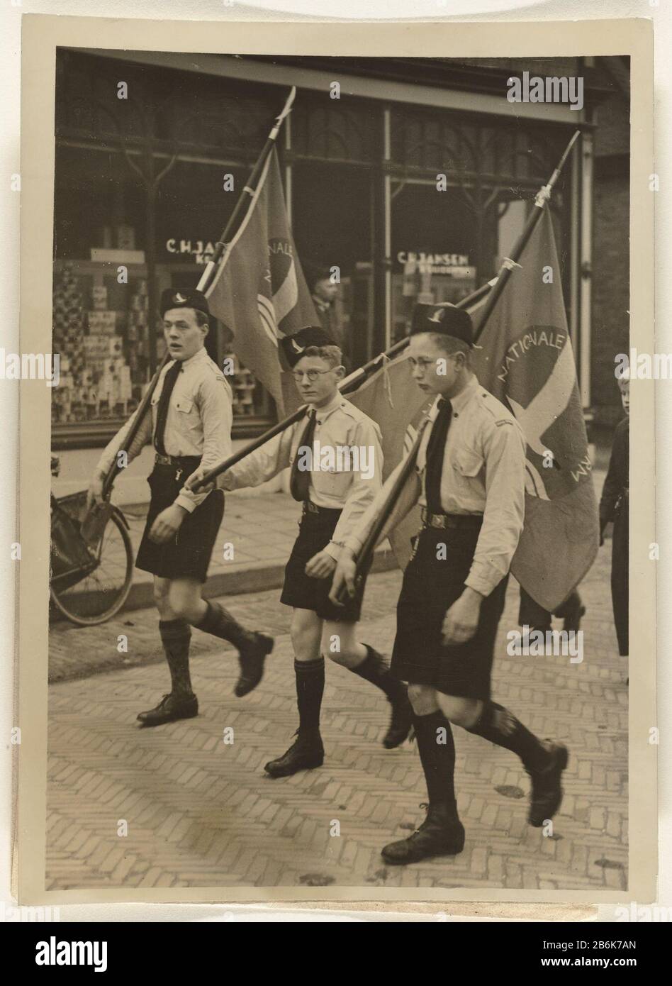 Tre ragazzi della National Youth Storm una parata pratica di bambini, tre ragazzi con una bandiera della National Youth Storm, la sezione giovanile del NSB, le strade Baarn. Produttore : fotografo: Associated Press Place produzione: Baarn Data: 15 Jan 1938 Materiale: Paper Tecnica: Fotografia dimensioni: H 19 cm. B × 14 cm. La sfilata di ToelichtingDe è un esercizio per il giorno in cui la principessa Juliana partorirà il suo primo figlio Beatrix. [Baruch Jet 2006] . Oggetto: Nascita Della Seconda Guerra Mondiale Beatrix Quando: 1938 - 1945 Foto Stock