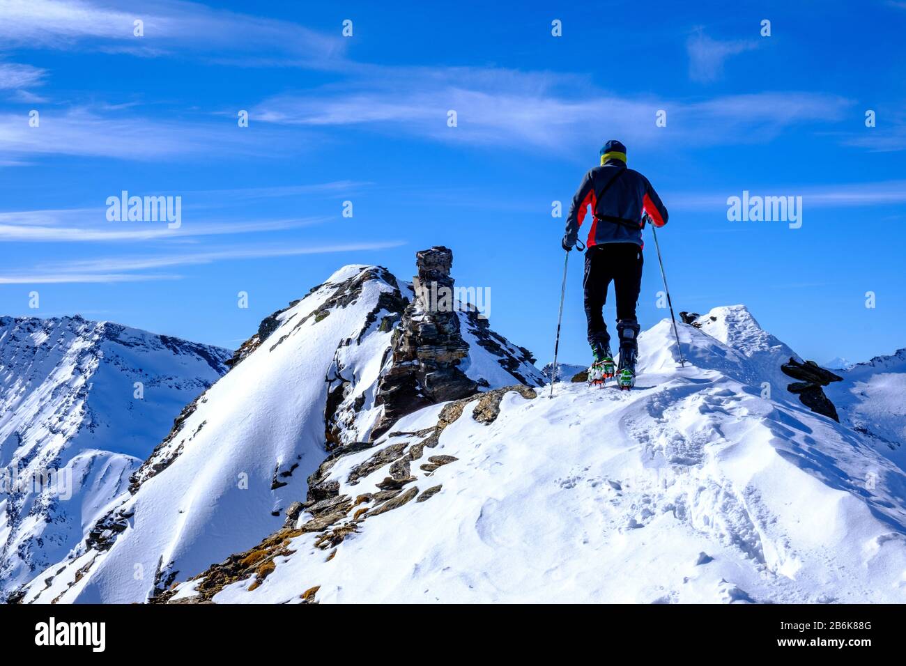 Sciatore di fondo che raggiunge la vetta del Piz de Mucia 2967 mt, San Bernardino, Svizzera Foto Stock