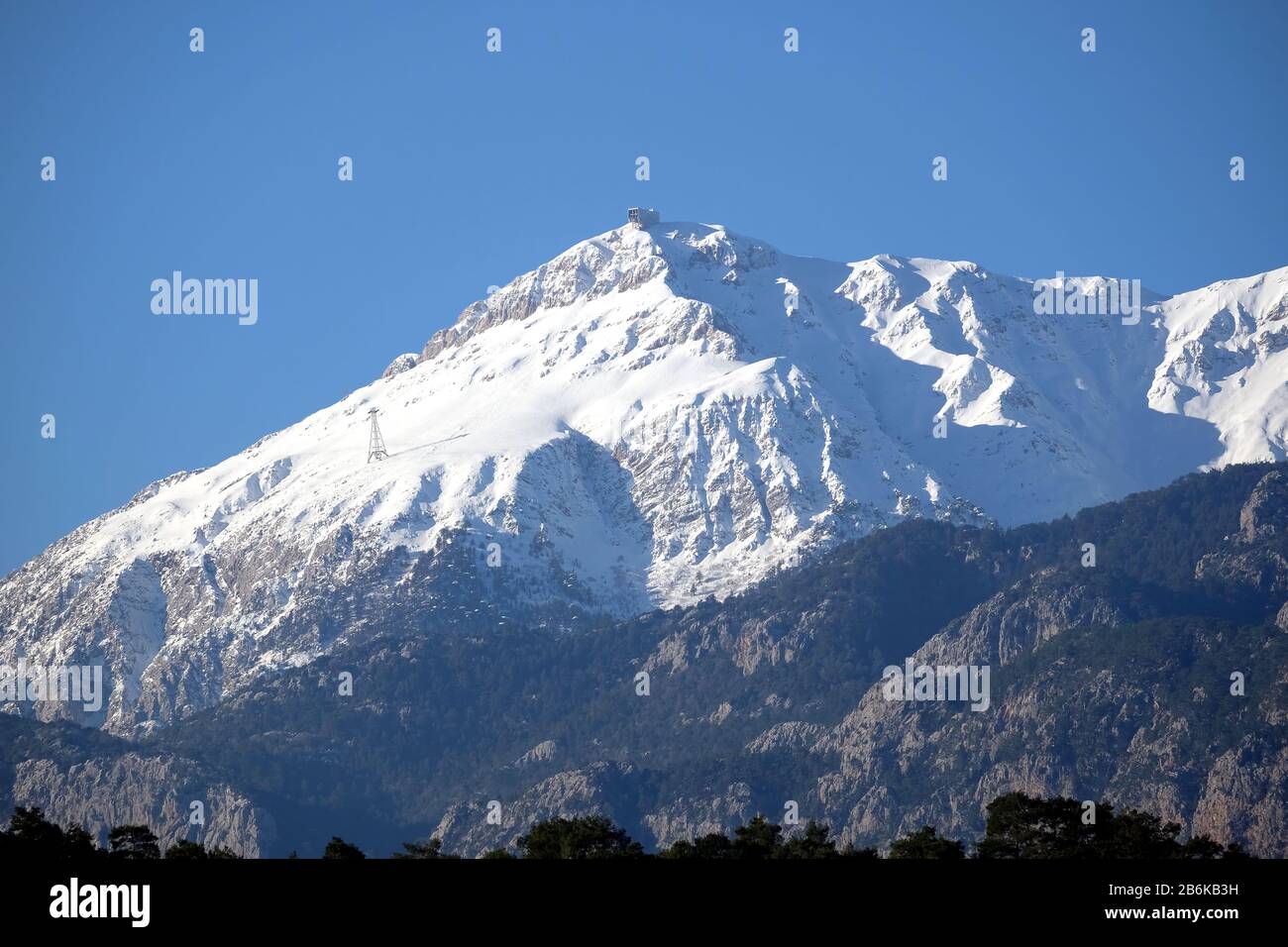 Paesaggio con vista frontale del monte Tahtali con neve bianca pulita sulla cima vicino Kemer con terminale a fune sulla cima. Tahtali è la T più alta Foto Stock