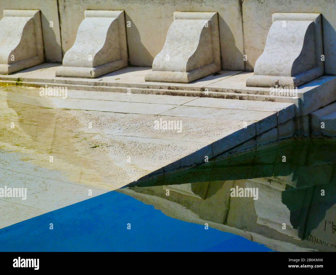 pietra bianca scolpita stile antico dettaglio architettonico di ordine colonna fregio. caduto, in parte sommerso in acqua piscina. decorativo classico dettaglio Foto Stock