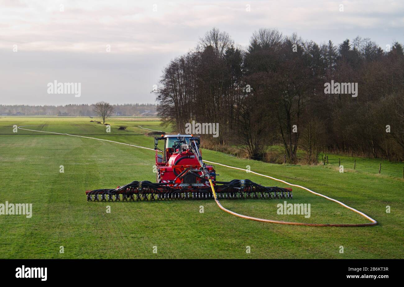 Agricoltura moderna: Iniezione di concime liquido in terra di erba usando un applicatore di tubo di resistenza Foto Stock