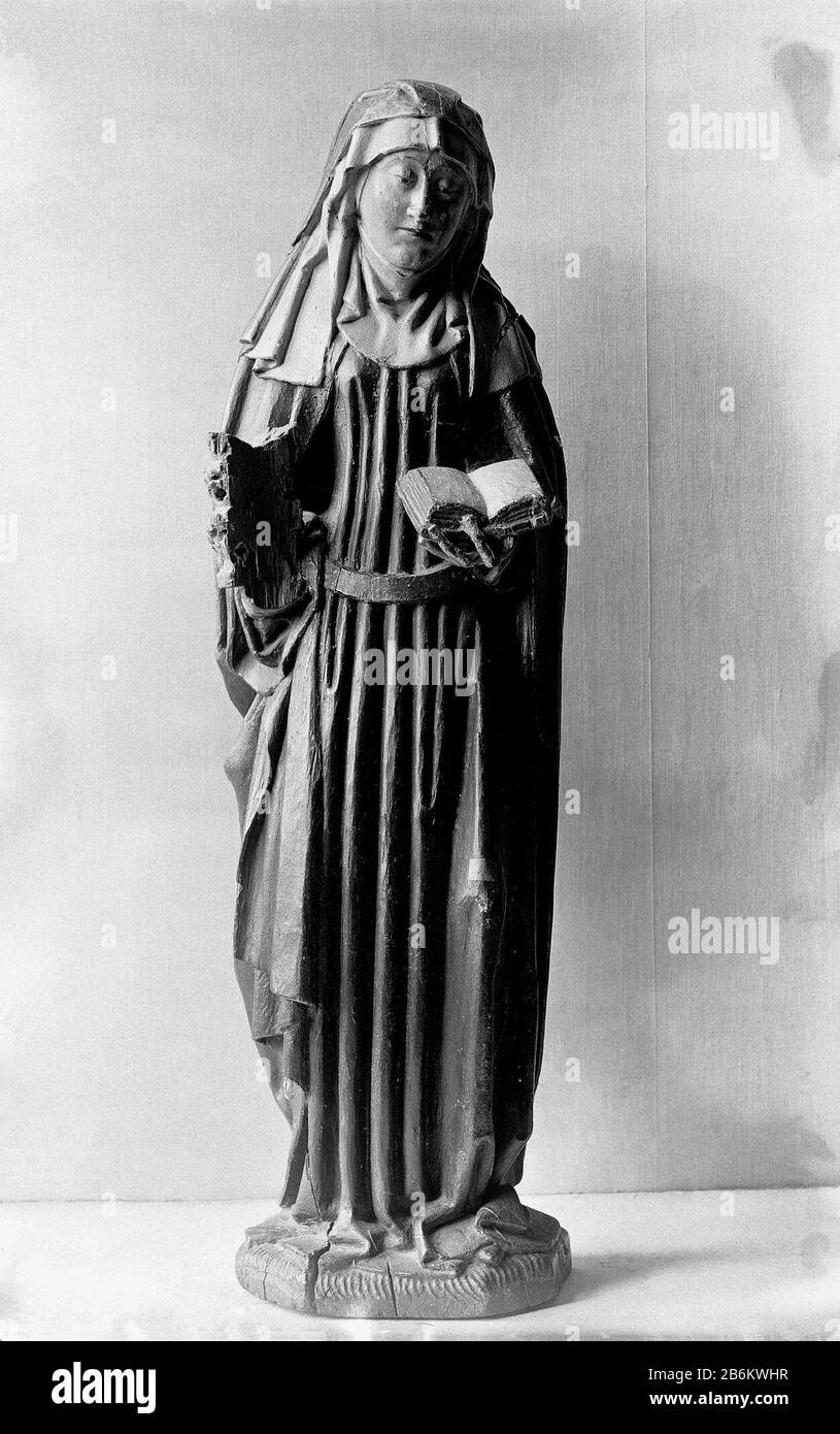 Elisabeth van Hongarije Zij staat op een veelhoekig grondje met het lincurbeen iets naar voren gebogen. Op de rechterhand houdt zij een tiara, op de linkereen opengeslagen boek; haar hoofd is iets terzijde geneigd. Zijdraagt een kindoek en bij de slapen een kapje onder de hoofddoek, Foto Stock