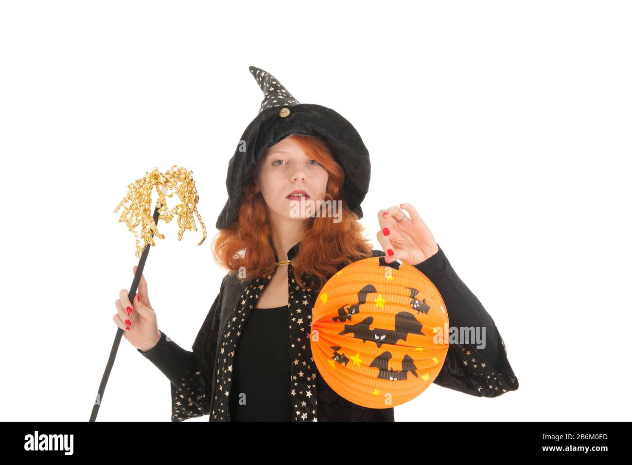 Giovane donna con capelli rossi come strega male durante halloween isolato su sfondo bianco Foto Stock