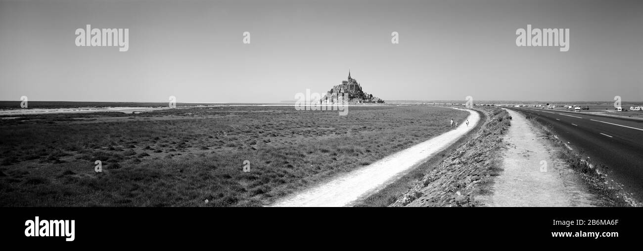 Strada che attraversa un paesaggio, Mont Saint-Michel, Normandia, Francia Foto Stock
