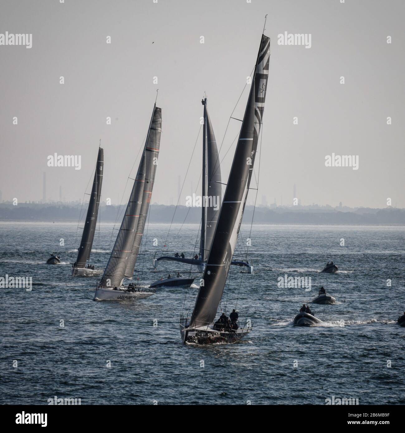 4 yacht, e varie piccole imbarcazioni, che navigano verso la macchina fotografica durante il giro dell'isola gara sul solent in una giornata di estati luminose. Foto Stock