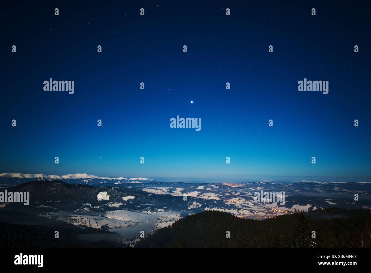 Bellissimo paesaggio con maestosi abeti alti che crescono tra ciuffi bianchi di neve contro il cielo blu in una soleggiata giornata invernale gelida. Concetto di trekking Foto Stock