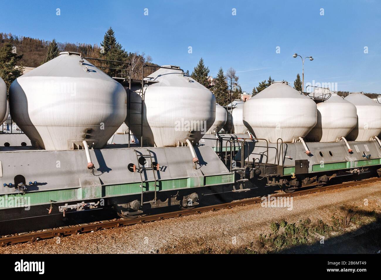Treno merci con contenitori di cemento Foto Stock