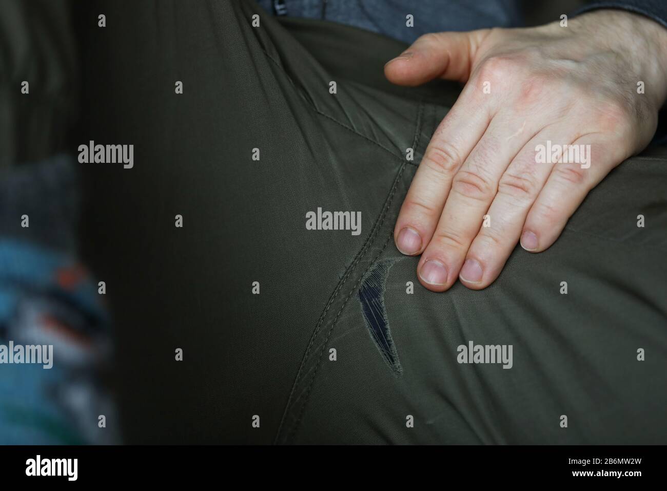 Uomo con gambe spalmate che mostra buchi sui pantaloni Foto stock - Alamy