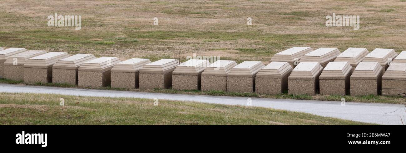 vista panoramica di molte volte sepolcrali allineate al cimitero in attesa di essere utilizzato per simboleggiare la morte e morire Foto Stock