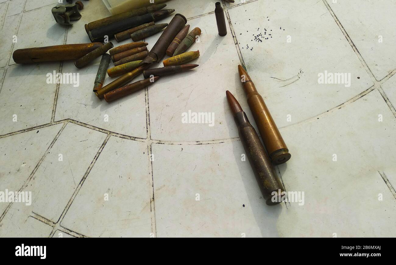 Antica collezione di proiettili militari risalenti alla Seconda guerra mondiale e polvere da sparo giacente su un tavolo bianco in plastica in italia Foto Stock