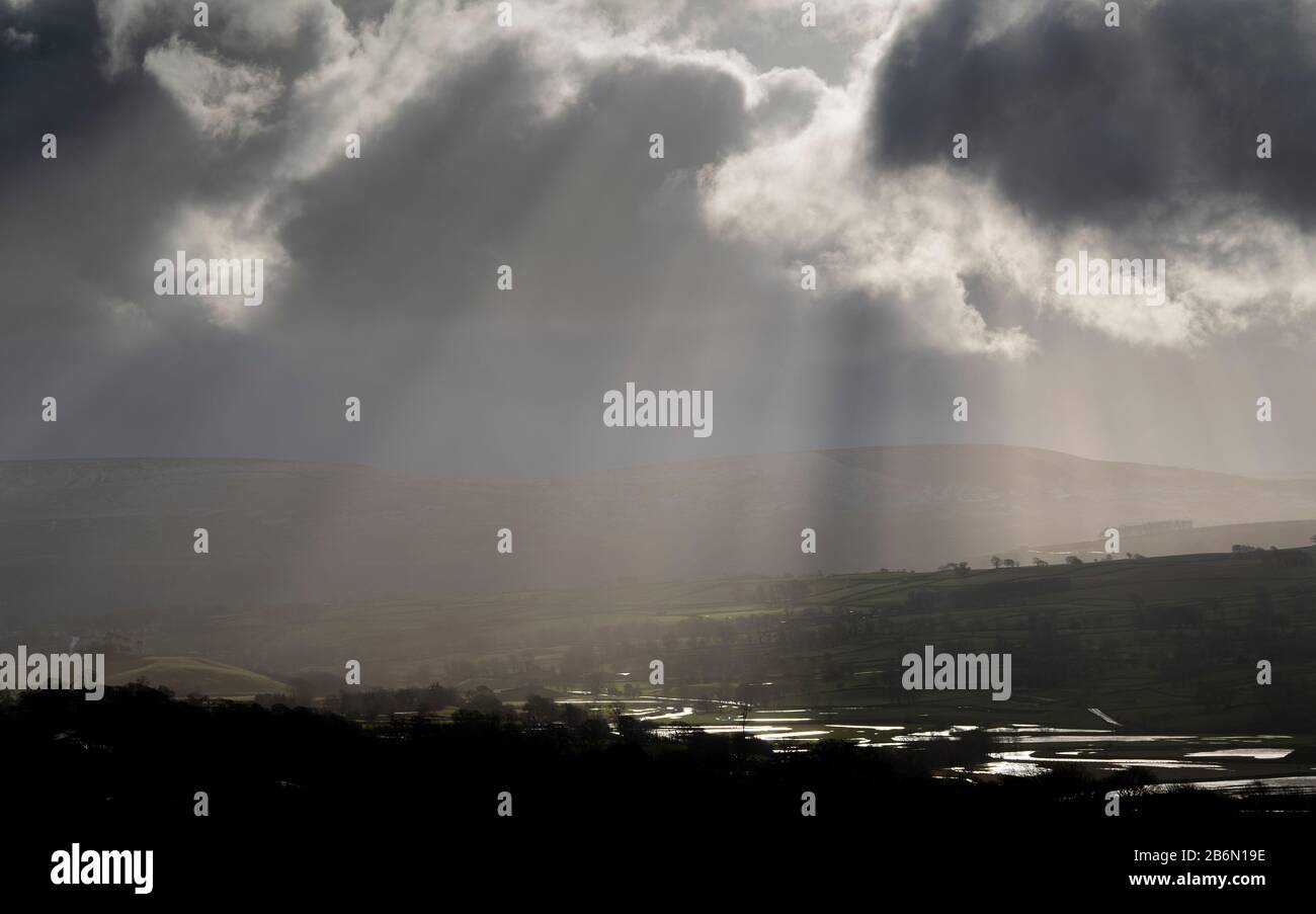 Raggi crepuscolari che attraversano le nuvole di tempesta dopo una tempesta a Wensleydale, Yorkshire Dales National Park, Regno Unito. Foto Stock