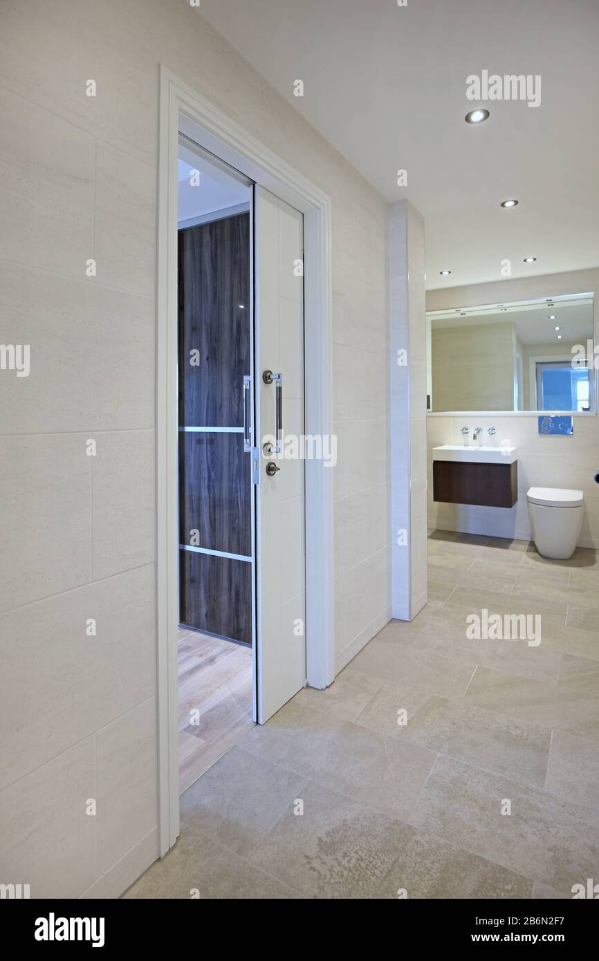 Interno di un appartamento nel Regno Unito che mostra una porta scorrevole tasca che si ritrae nel muro per risparmiare spazio Foto Stock