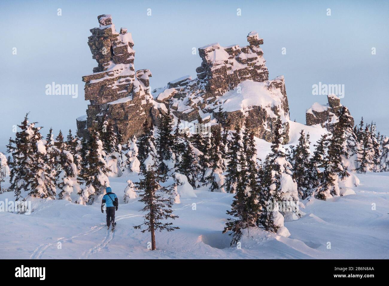 Un viaggiatore cammina nel parco nazionale in inverno sullo sfondo di una grande scogliera Foto Stock