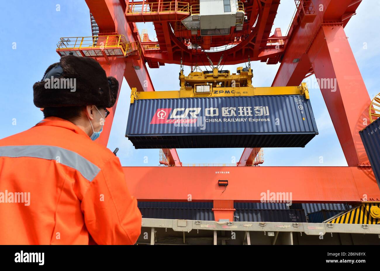 (200311) -- XI'AN, 11 marzo 2020 (Xinhua) -- UN lavoratore dirige l'operazione di sollevamento dei container presso una stazione logistica nella stazione ferroviaria di Xinzhu a Xi'an, nella provincia Shaanxi della Cina nord-occidentale, 11 marzo 2020. Un treno merci Cina-Europa completamente caricato con 50 carrozze di vestiti, componenti elettronici e elettrodomestici ha lasciato la stazione ferroviaria Xinzhu a Xi'an City per Mannheim in Germania il mercoledì. (Foto Di Tang Zhenjiang/Xinhua) Foto Stock