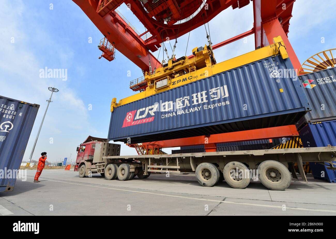 (200311) -- XI'AN, 11 marzo 2020 (Xinhua) -- UN lavoratore dirige l'operazione di sollevamento dei container presso una stazione logistica nella stazione ferroviaria di Xinzhu a Xi'an, nella provincia Shaanxi della Cina nord-occidentale, 11 marzo 2020. Un treno merci Cina-Europa completamente caricato con 50 carrozze di vestiti, componenti elettronici e elettrodomestici ha lasciato la stazione ferroviaria Xinzhu a Xi'an City per Mannheim in Germania il mercoledì. (Foto Di Tang Zhenjiang/Xinhua) Foto Stock