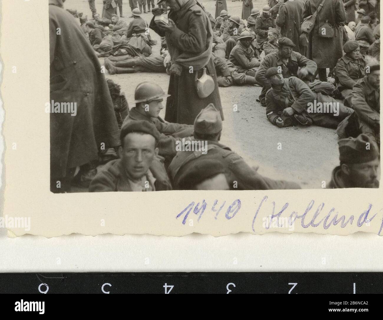 Franse krijgsgevangenen prigioniero francese di guerra, la maggior parte di loro seduti a terra. Sullo sfondo si possono vedere alcuni soldati tedeschi. I negozi hanno le indicazioni per i Frans. Produttore : fotografo: Anonimo luogo produzione: Francia Data: Giu 1940 - lug 1940 caratteristiche Fisiche: Gelatina argento materiale di stampa: Carta Tecnica: Gelatina argento stampa dimensioni: H 5.5 cm. B × 7 cm. Oggetto: Occupazione  prigioniero di guerra (dopo la battaglia) Secondo mondo Quando: 1940 - 1940 Foto Stock