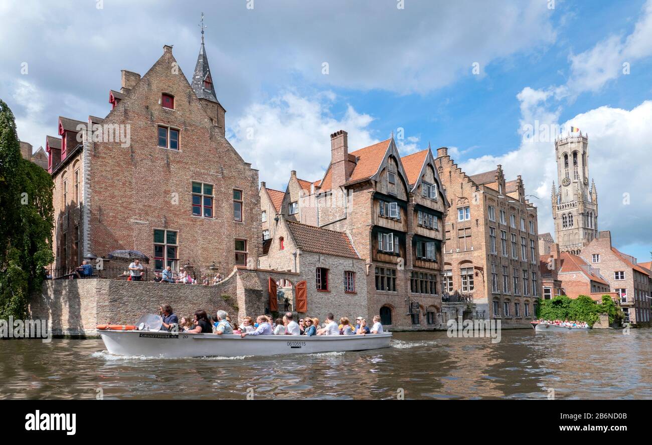 Barche turistiche sui famosi canali di Bruges / Brugge, Belgio. Sulla destra si trova il campanile medievale. Foto Stock