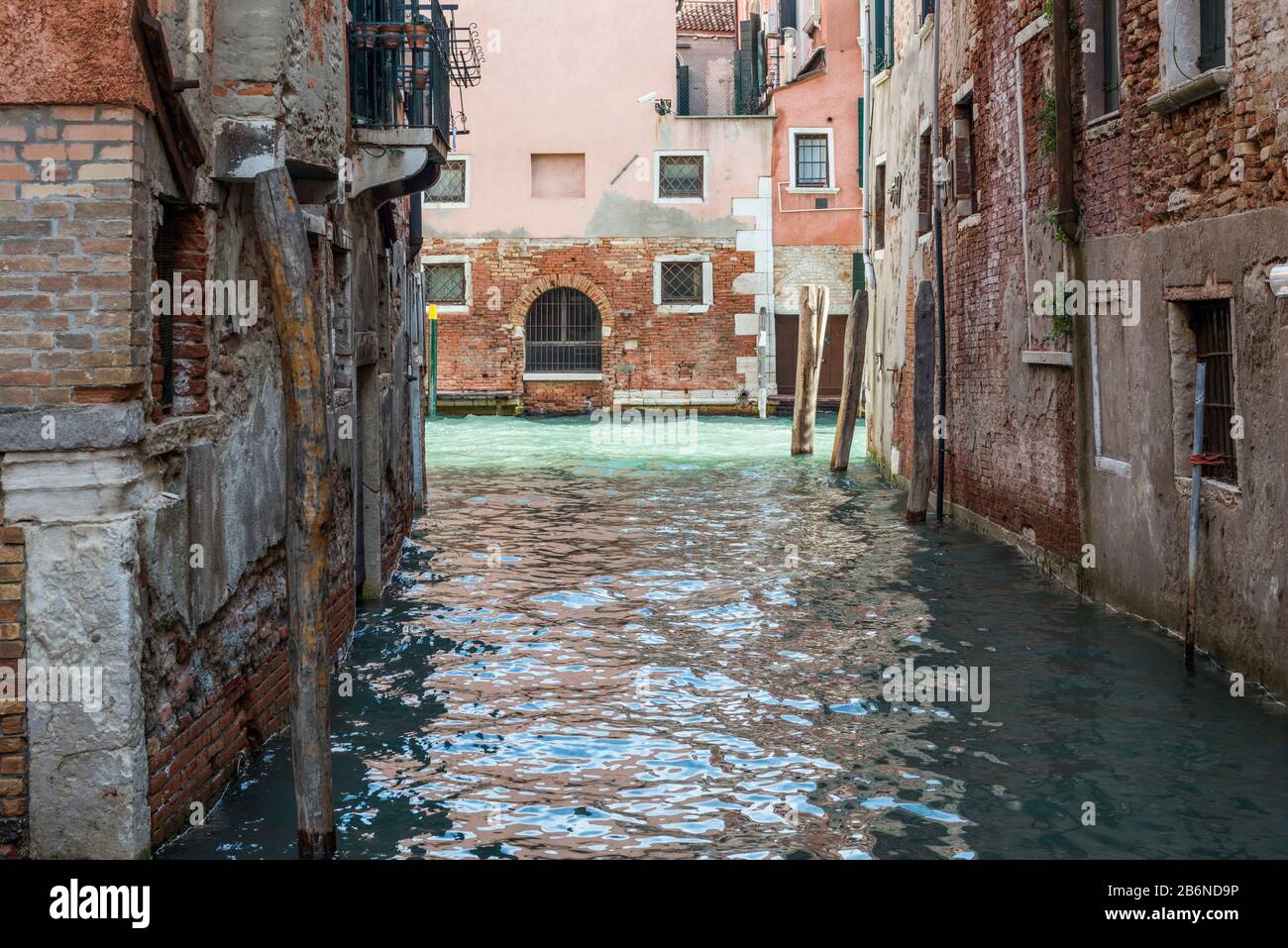 Canale d'acqua vuoto tra antichi edifici di Venezia Foto Stock