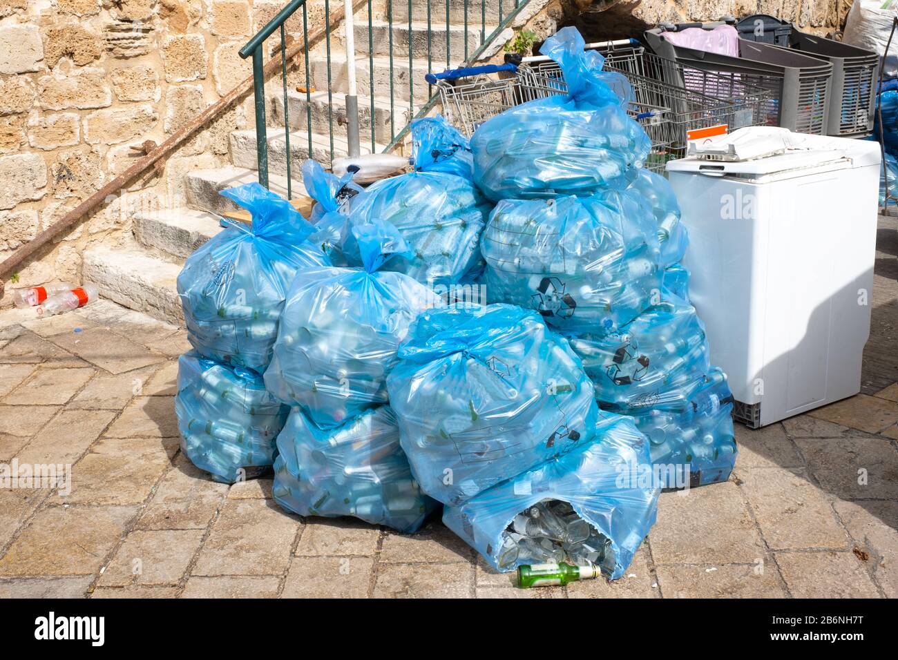 Immondizia in sacchetti di plastica blu sulla strada della città orientale. In sacchetti di plastica blu bottiglie Foto Stock
