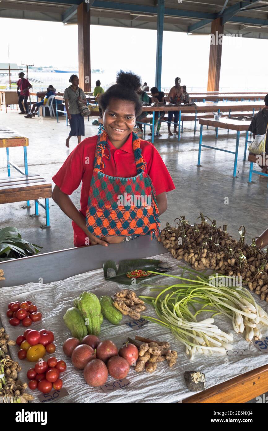 dh PNG mercato locale fornitore ALOTAU PAPUA NUOVA GUINEA sorridente donna nativa a frutta bancarella verdure persone gente del posto Foto Stock