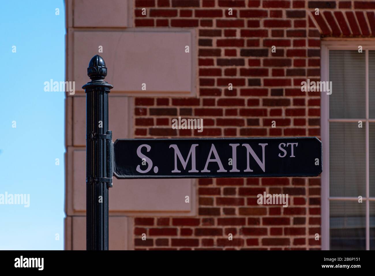 Un cartello stradale per South Main Street con uno sfondo di mattoni, lettere bianche e uno sfondo nero Foto Stock