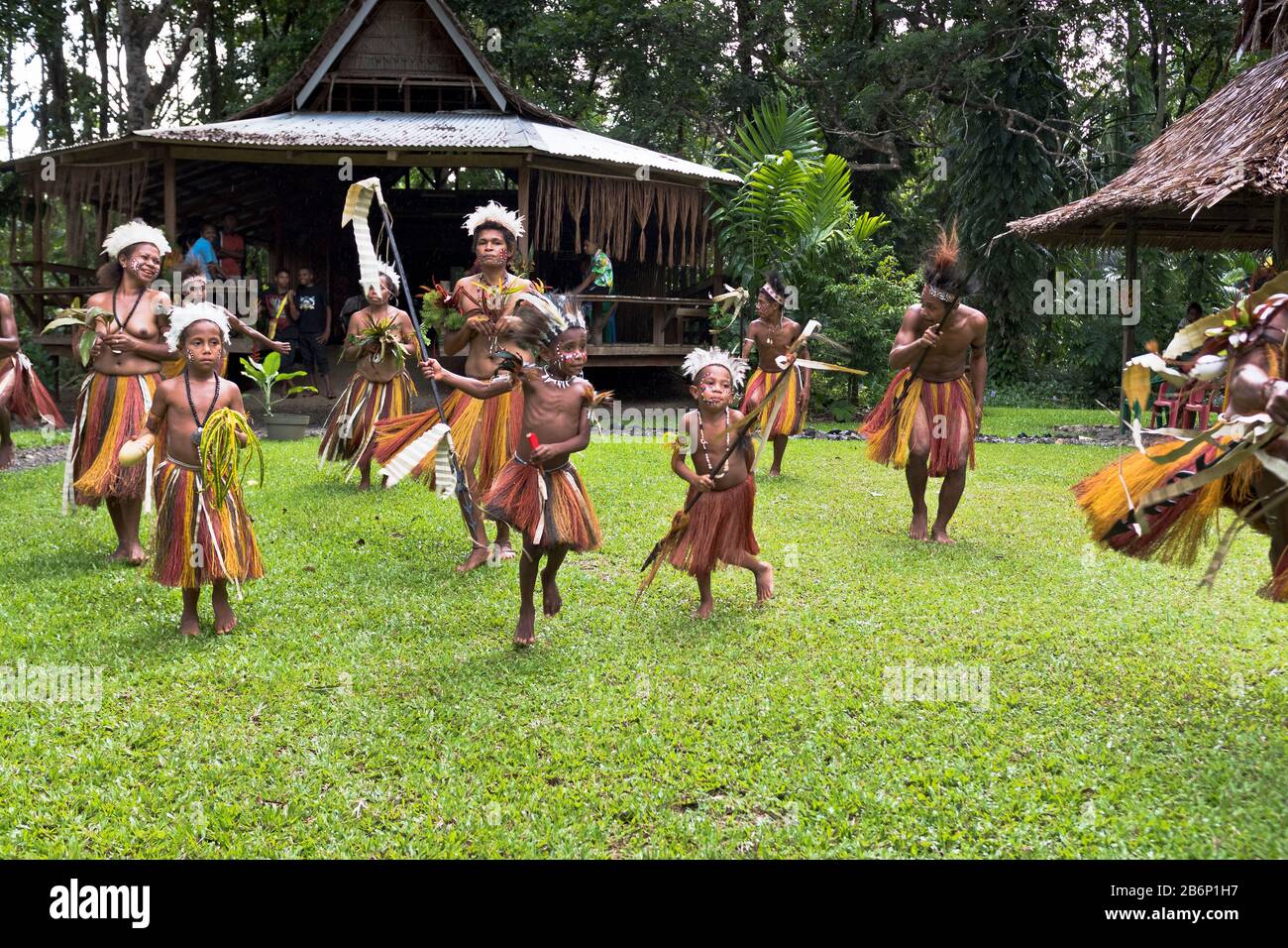dh PNG ballerini nativi ALOTAU PAPUA NUOVA GUINEA tradizionale accoglienza i visitatori del villaggio bambini danza cultura tribale famiglia benvenuto locali tribù Foto Stock