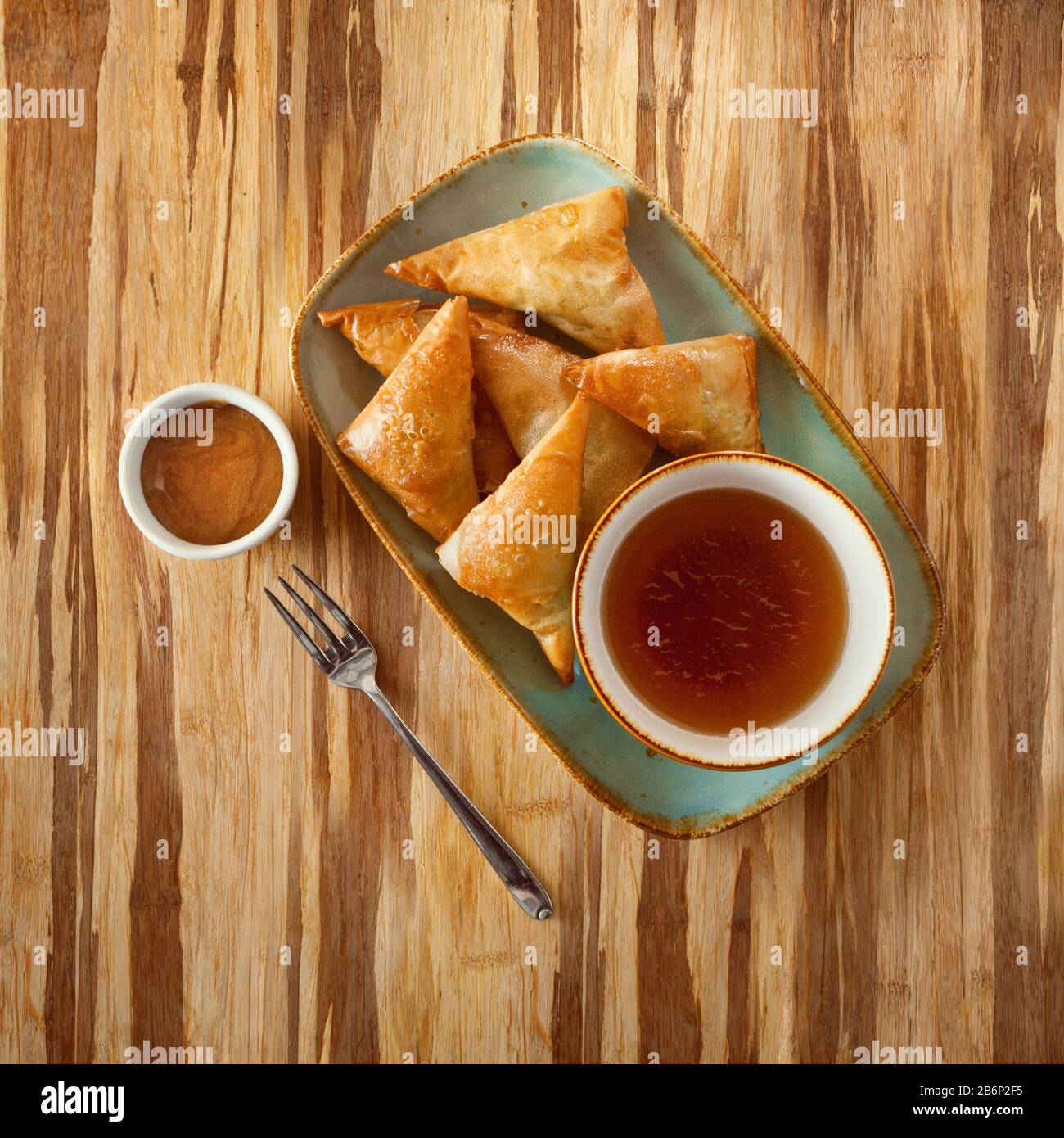 Cibo marocchino, ripiene pasties piatto su una piastra con zuppe e salse, su di un tavolo di legno e copiare lo spazio per testo Foto Stock