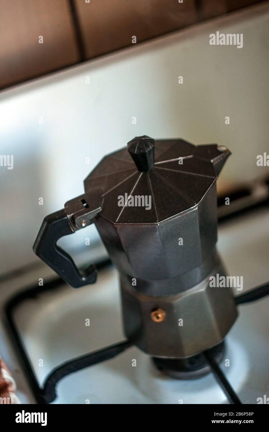 Una vecchia macchina da caffè geyser in alluminio è in piedi sulla stufa. Foto Stock