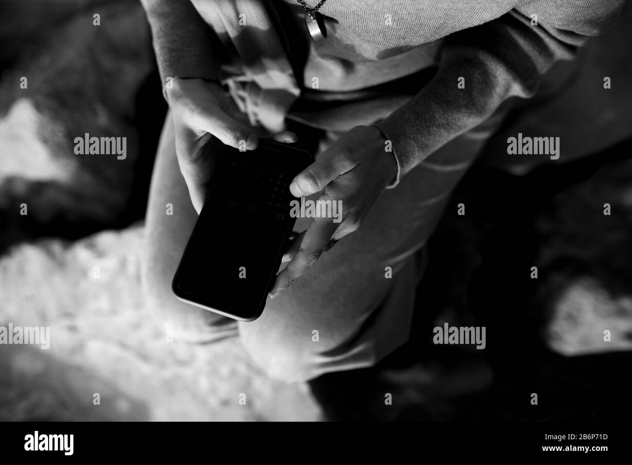 Primo piano foto di mani femminili che tengono il telefono cellulare e scattano foto del lago in una giornata torbida. Sta inviando messaggi di testo sullo smartphone e sta prendendo selfie. Foto Stock