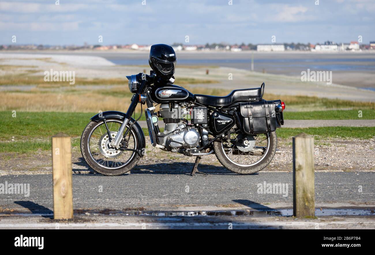 Royal Enfield Bullet 500 moto parcheggiata a le Hourdel (nel dipartimento francese della Somme) con la baia del mare Somme in background. Foto Stock