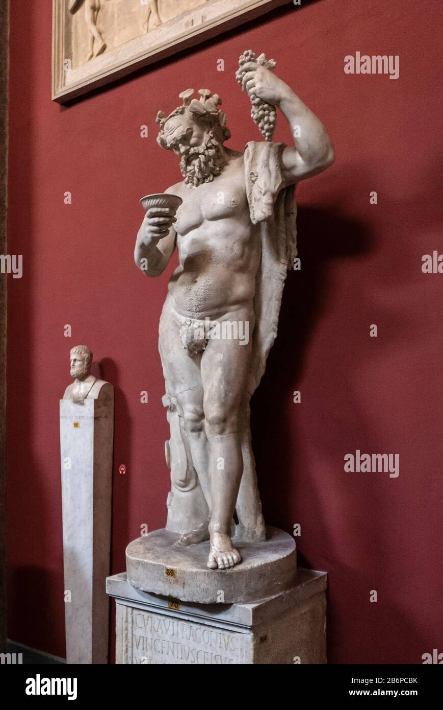 Antica scultura di Bacco, dio romano dell'agricoltura, del vino e della fertilità. Qui con un grappolo di uva nel Museo Vaticano, Roma, Italia. Foto Stock