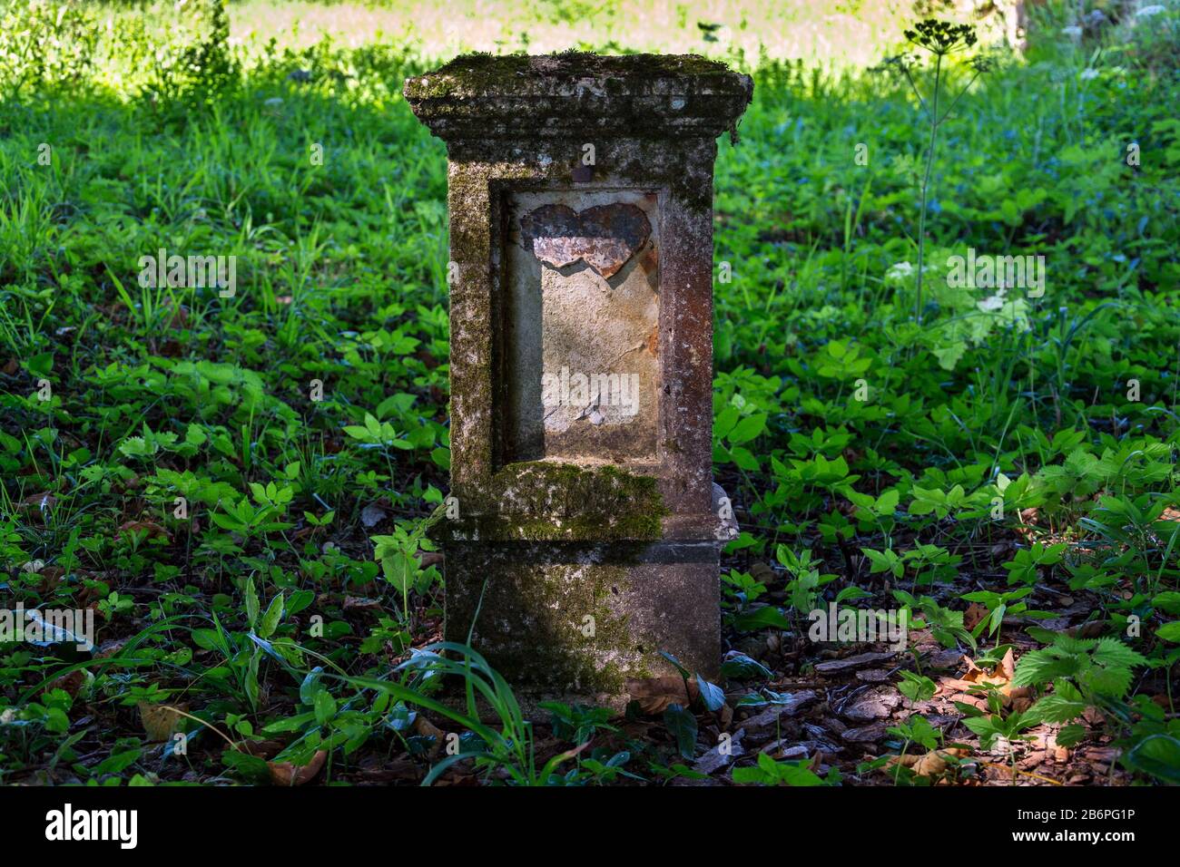 Broken cuore su vecchia lapide, cimitero in una giornata di sole, amore, matrimonio, morte e concetto di fine vita Foto Stock