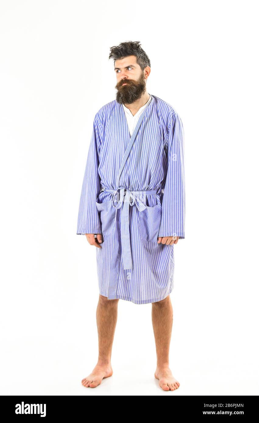 Un concetto che non ha dormito bene. Guy stand dritto in accappatoio, spazio per copiare. Hipster con barba e baffi con capelli capienti sembra stanco, sonnolento. Uomo con faccia assonnata su sfondo bianco. Foto Stock