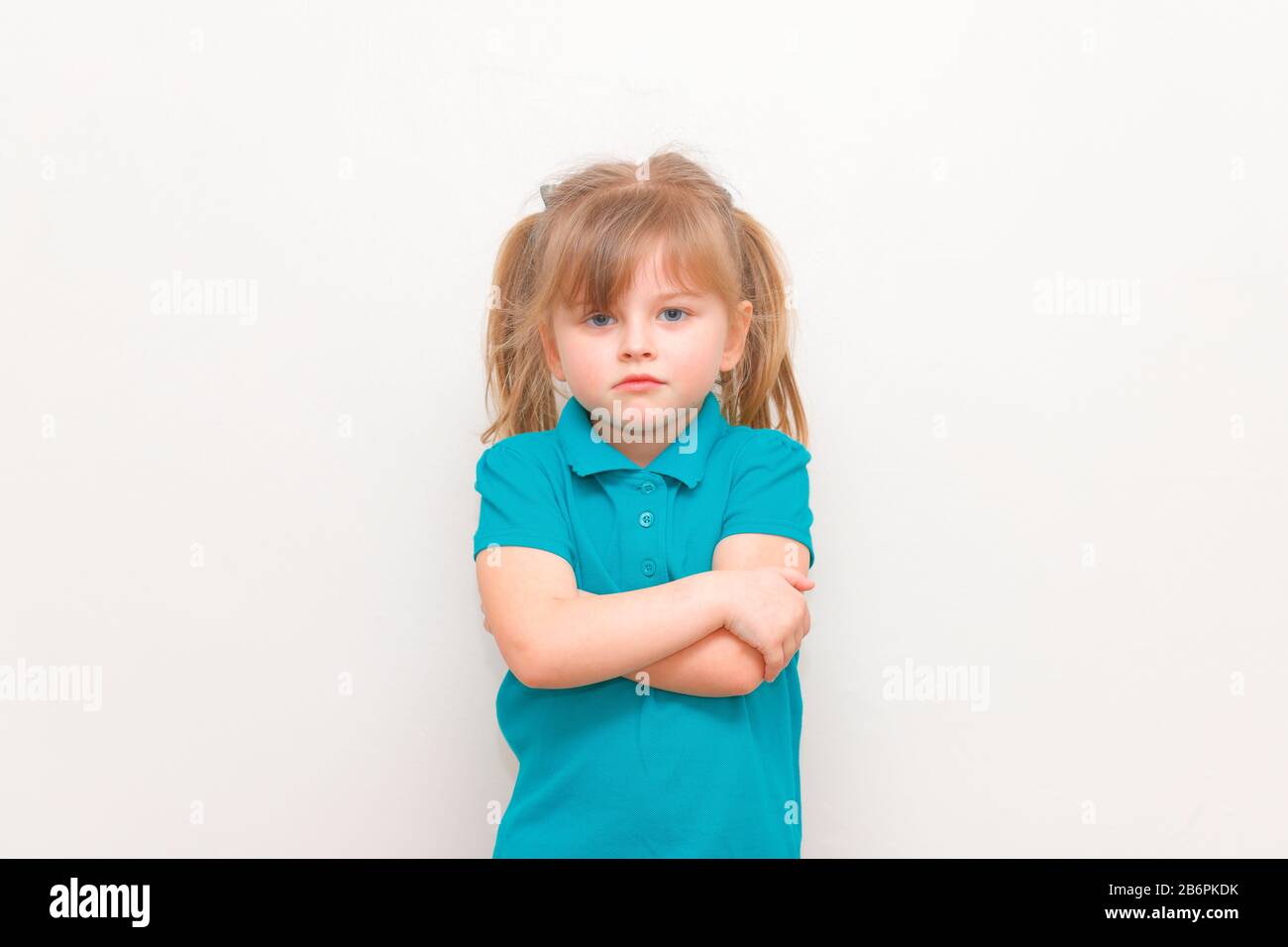 Una ragazza lttle in uniforme scolastica cercando infelice Foto Stock