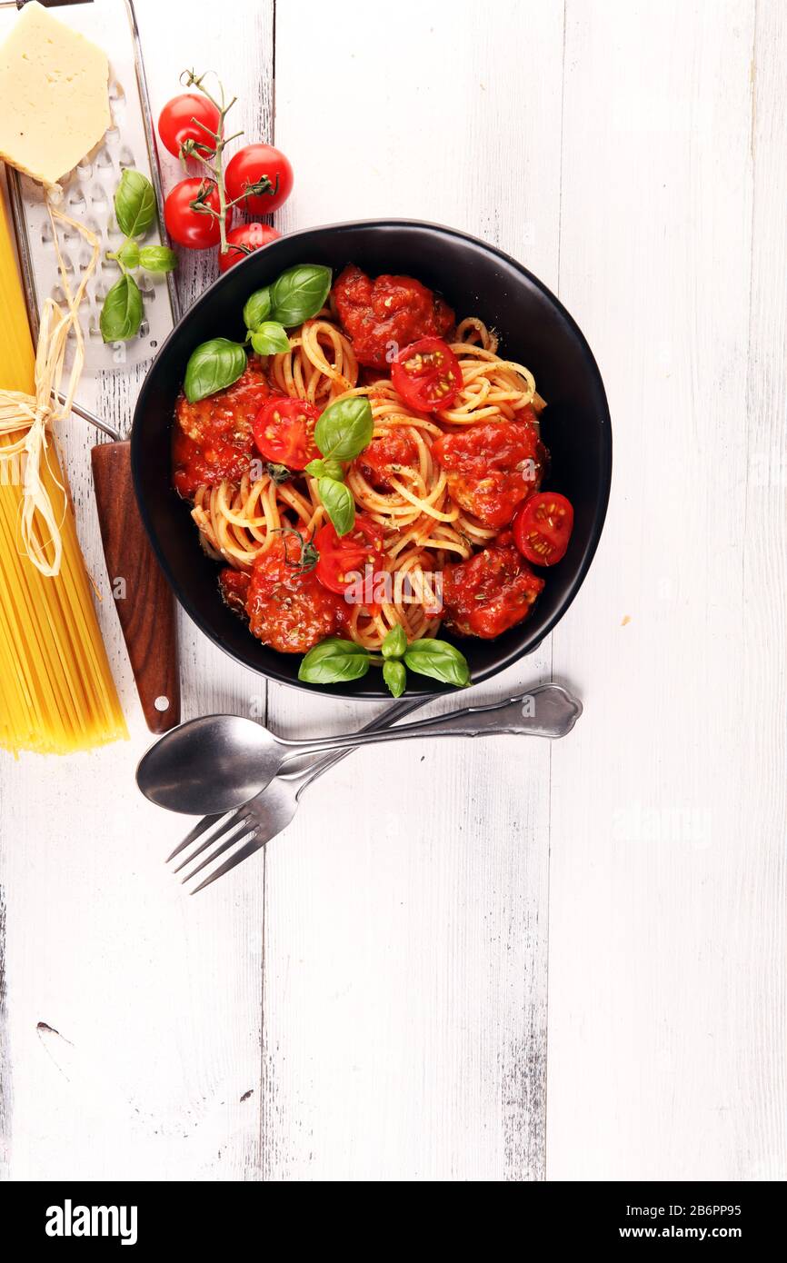 Gustosi e appetitosi spaghetti classici italiani con salsa di pomodoro, parmigiano e basilico con ingredienti Foto Stock
