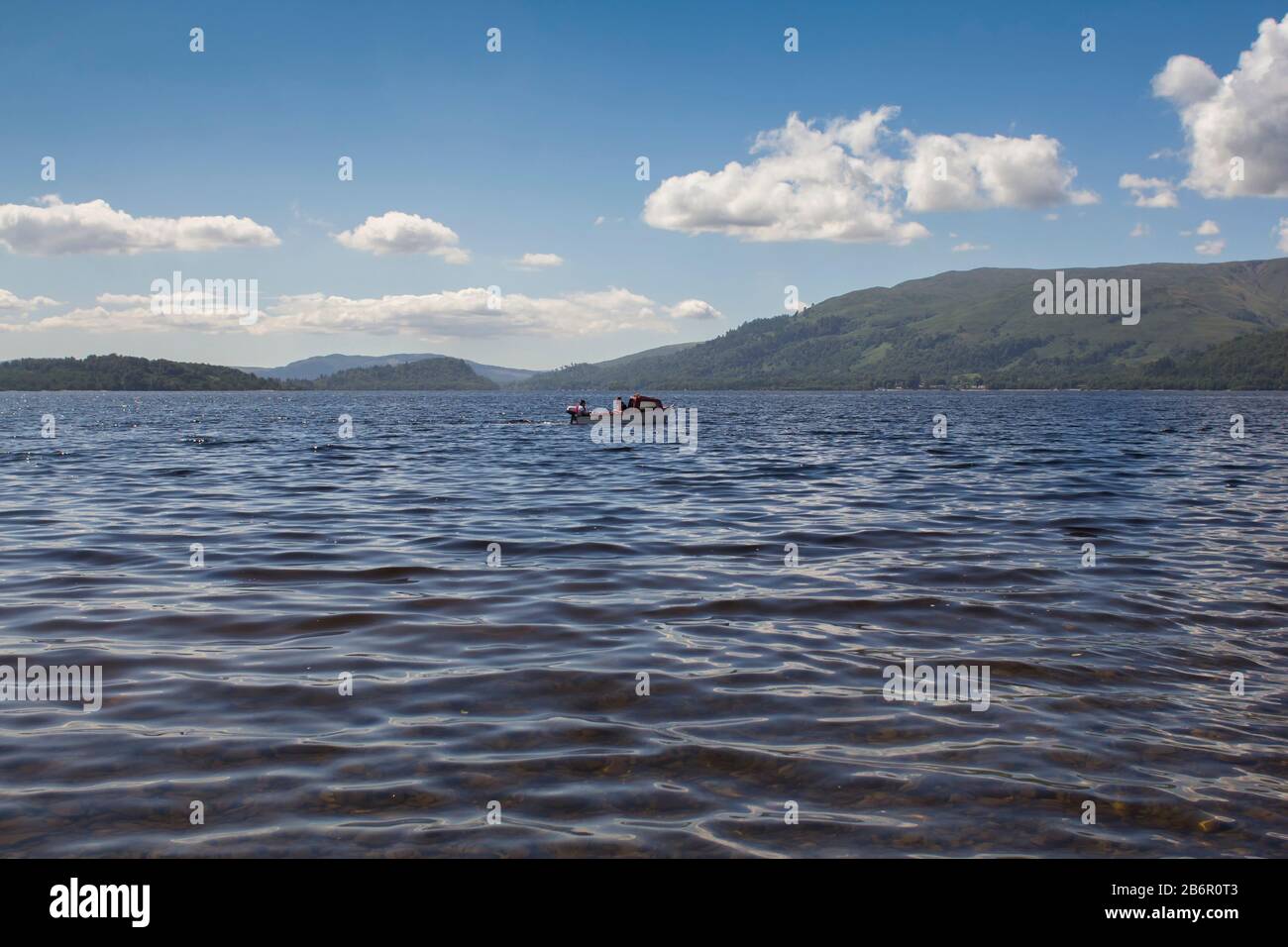 Due uomini che pescano in barca sul Loch Lomond nelle Highlands scozzesi in una giornata estiva Foto Stock