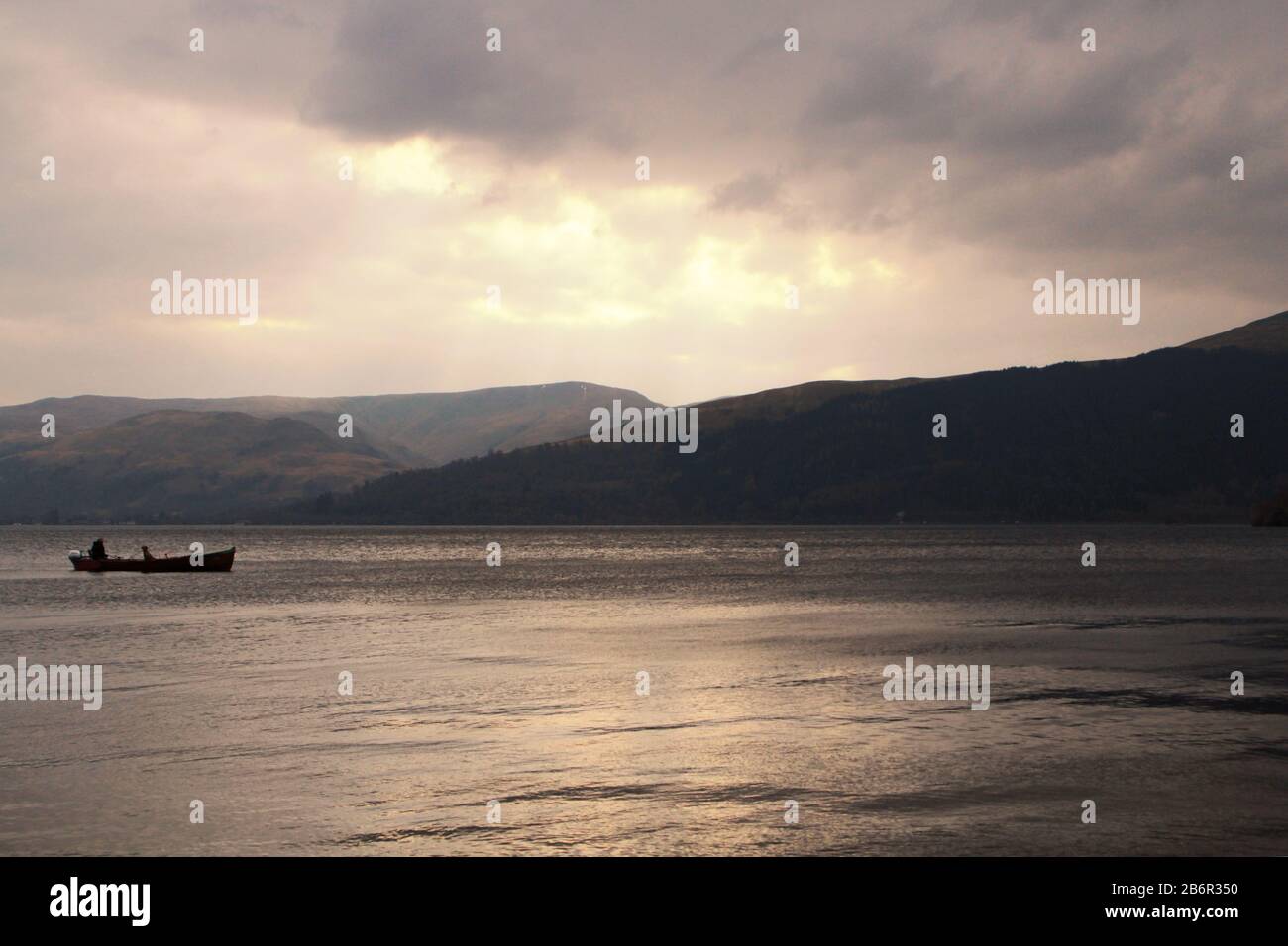 Una barca ormeggiata in una remota baia di Loch Lomond nelle Highlands scozzesi in una giornata invernale Foto Stock