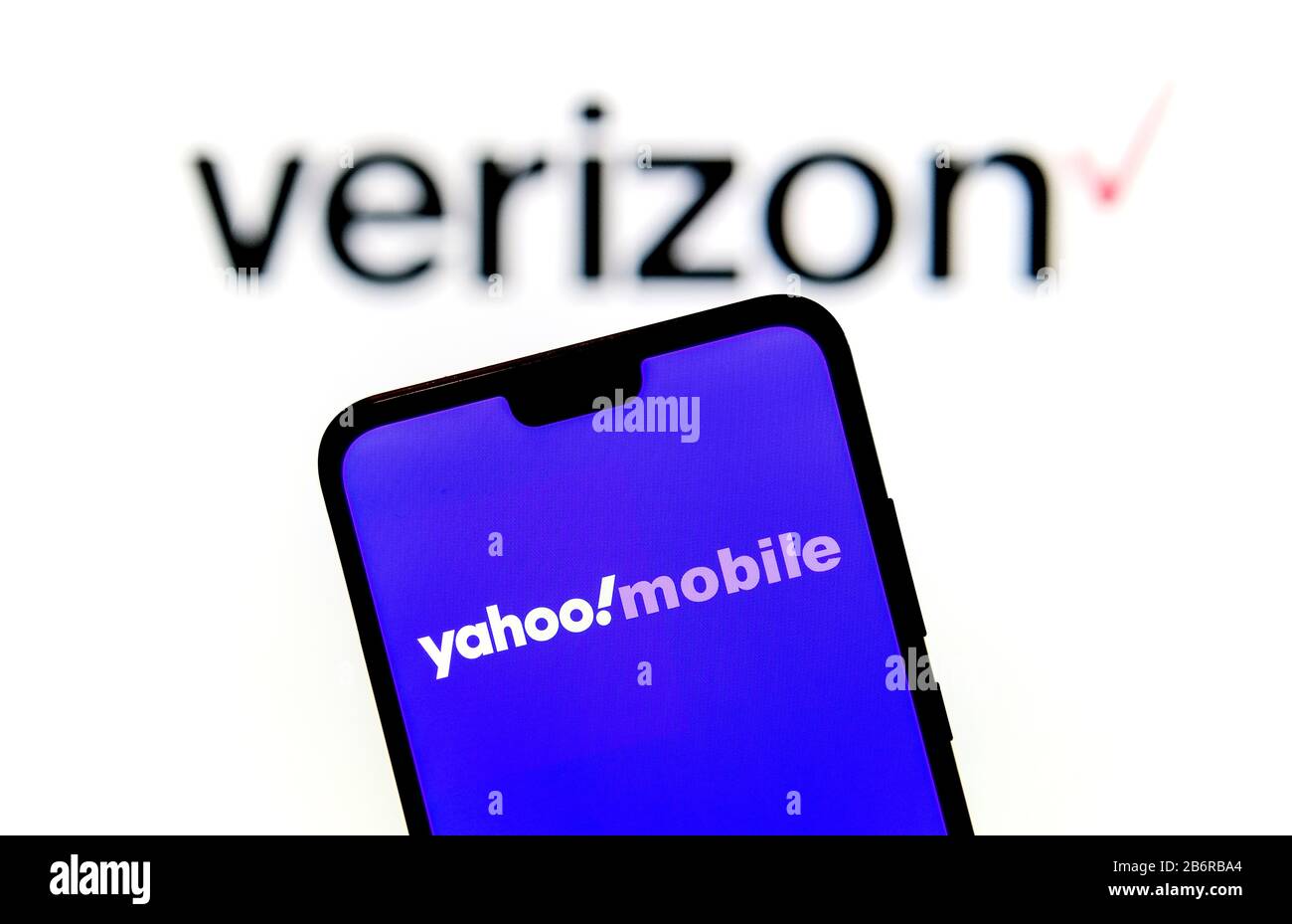 Stone / Regno Unito - 11 Marzo 2020: Yahoo! Logo mobile sulla silhouette dello smartphone tenere in mano e logo Verizon sullo sfondo sfocato. Foto Stock