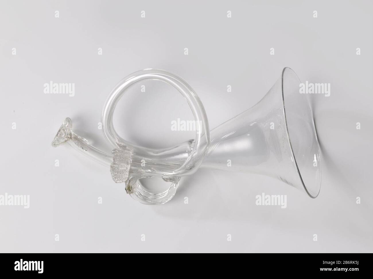 Glas in de vorm van een jachthoorn Gladde, rongebogen buis, uitlospin in een wijde klankbeker; aan de smaalle zijde een aangezet mondstuk. Op de buis een C-vormig or. De wiring wordt bijeengehouden porta een brede, in wafelpatroon gestempelde band. Produttore : glasblazer: AnoniemPlaats fabbricante: Nederland Dating: CA. 1700 - ca. 1800 kenmerken Fisici: Helder, kleurloos glas Materiale: Glas Techniek: Glasblazen dimensioni: H 24,2 cm. × d 12,4 × b 5,7 Foto Stock