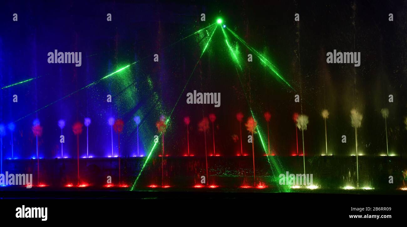 Fontane colorate. Bella esposizione laser e fontana. Grande spettacolo di fontana luminosa a getto d'acqua con danza decorativa multicolore di notte. Scuro b Foto Stock