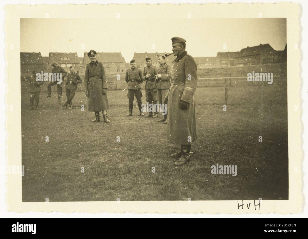 Groep Wehrmacht militaren un gruppo di soldati Wehrmacht in piedi in erba da una recinzione. Due cappotti indossano lunghi, uno dei quali sta fumando un tubo. Sullo sfondo huizen. Produttore : fotografo: Anonimo luogo produzione: Hoek van Holland datazione: 1940 - 1941 caratteristiche Fisiche: Gelatina argento materiale di stampa: Carta Tecnica: Gelatina argento stampa dimensioni: H 6 cm. B × 9 cm. Oggetto: Occupazione  oorlogla società, l'unità, la troop  servizio militare seconda guerra occupazione dei Paesi Bassi Quando: 1940 - 1941 Foto Stock