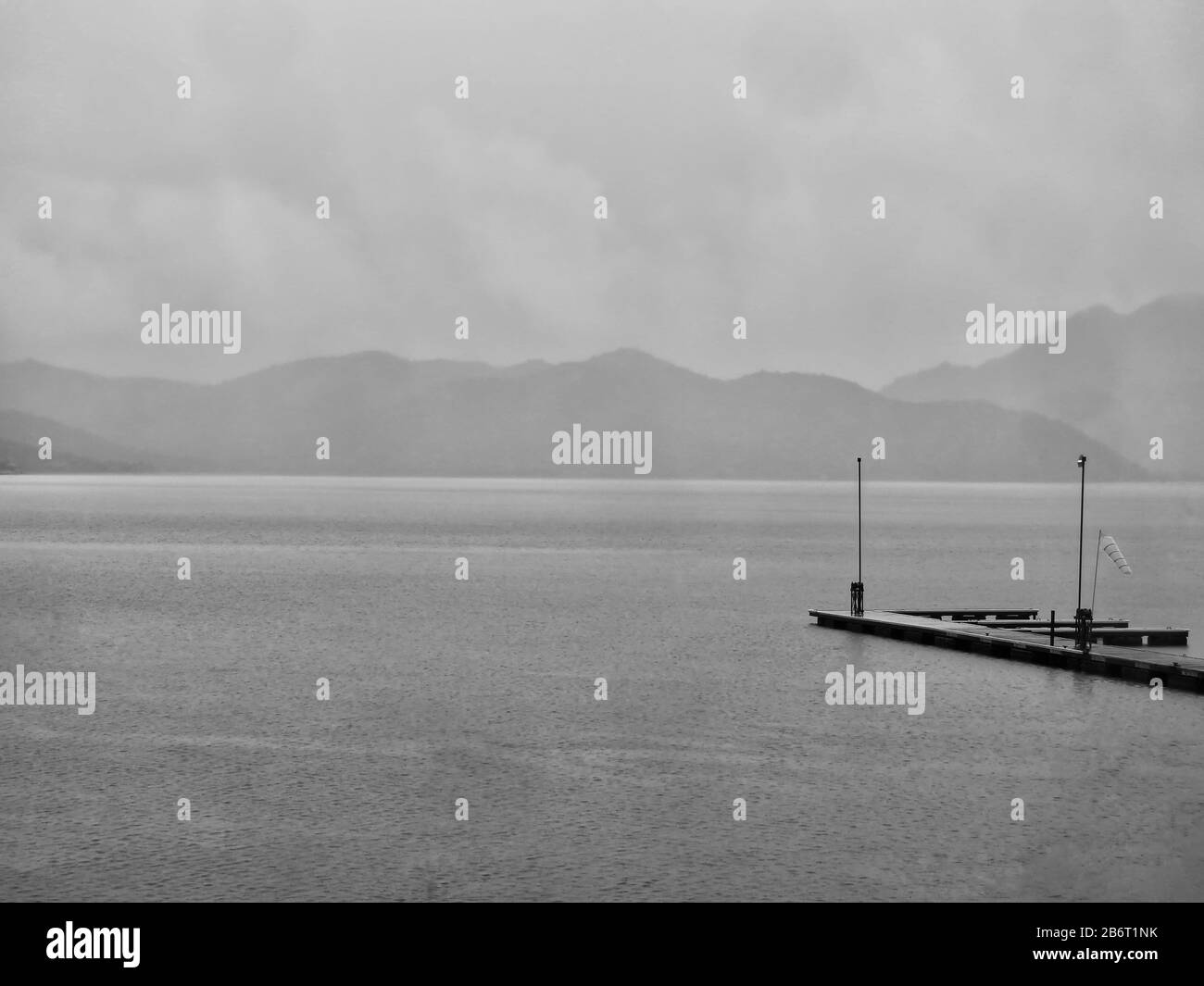 Giornata delle piogge al lago con banchina in primo piano Foto Stock
