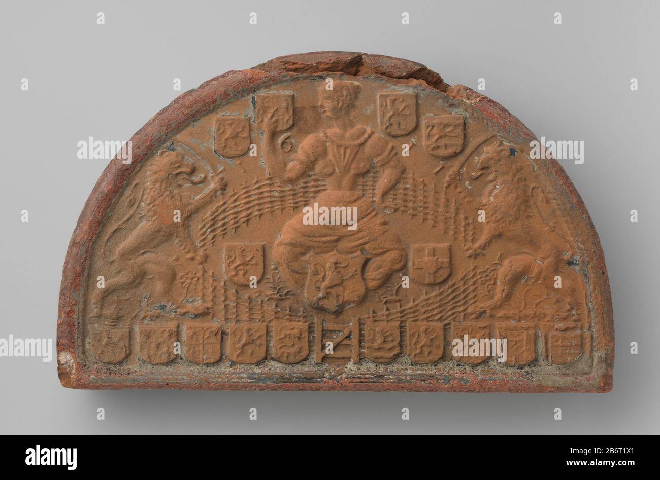 Halfrontde steen. Centraal een vrouw met het hoofd naar links gewend en opgeheven rechterarm. OM haar heen een afrasting incontrò in het midden een hek. Daarbuiten links en rechts een staande leeuw met een sabel in de klauw. M.B. vier wapenschilden, drie wapenschilden. Langs de onderrand 10 wapenschilden. Produttore : vervaardiger: AnoniemPlats fabbricante: Nederland datazione: 1611 kenmerken Fisico: Aardewerk Materiale: Aardewerk Techniek: Stempelen / bakken dimensioni: Geheel: H 21,4 cm. × b 34,7 cm. × d 6,5 cm. Data: 1611 - 1611 Foto Stock