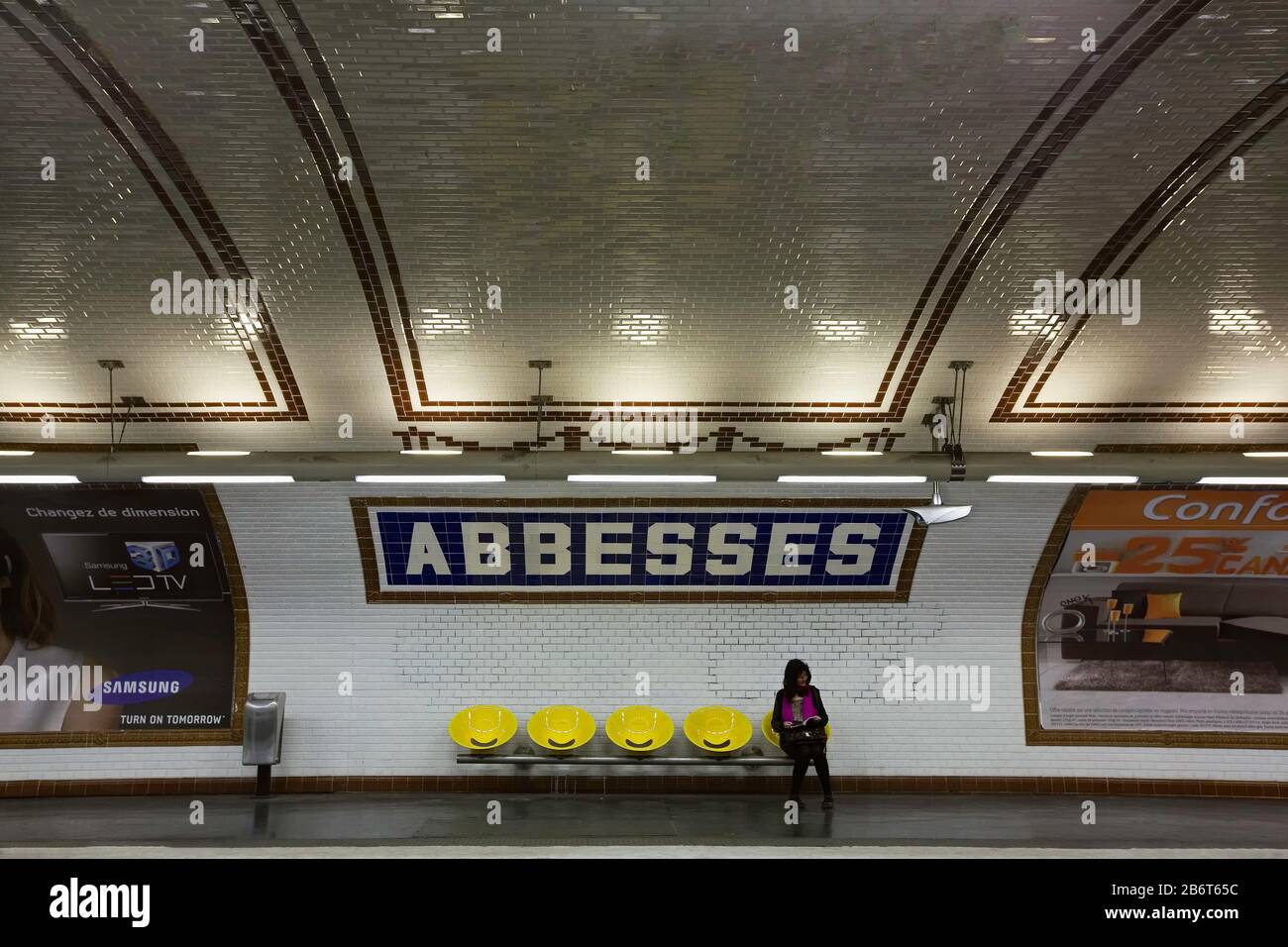 Donna in attesa su un treno solo sulla piattaforma alla stazione della metropolitana Abbesses, Montmartre, Right Bank, Parigi, Francia, Europa, colore Foto Stock
