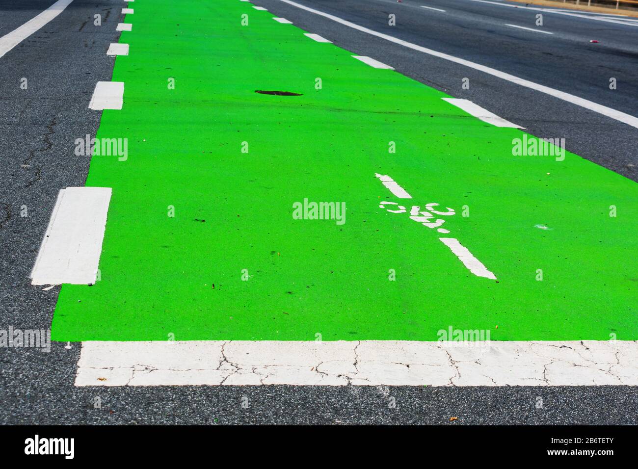 Primo piano. La superficie della pista ciclabile di colore verde comunica agli utenti della strada che una parte della strada è stata messa da parte per preferenziale o dedicata Foto Stock