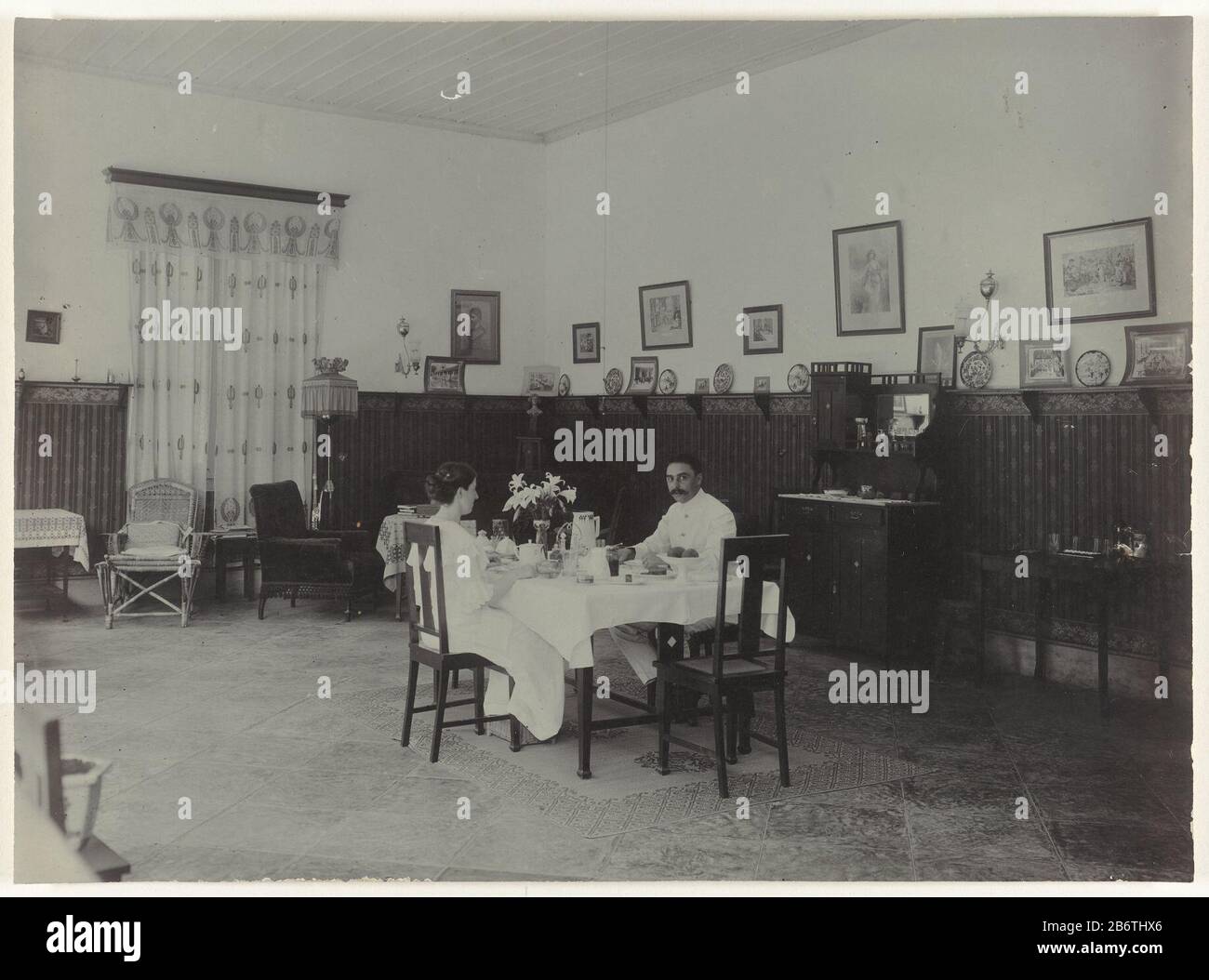 Het echtpaar Letterie in de eetkamer van hun huis a Mojosari la coppia di lettere nella sala da pranzo della loro casa a Mojosari. Produttore : fotografo: Anonimo luogo di produzione: Mojosari dating : 1913 Materiale: Carta fotografica Tecnica: Fotografia dimensioni: H 16.5 cm. B × 22,5 cm. Oggetto: Salotto, 'salon'Wanneer 1913 - 1913 Foto Stock