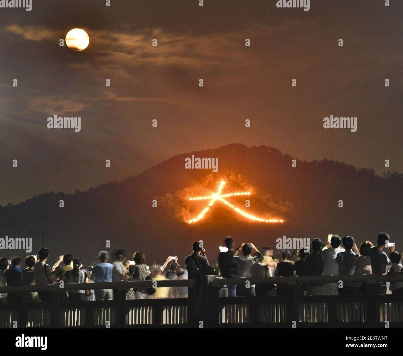 La foto scattata la notte del 16 agosto 2019, mostra un falò a forma di gigante cinese che significa "grande" su un lato della montagna durante il Dimonji Festival, uno degli eventi più famosi di Kyoto. Nel festival, formalmente conosciuto come Gozan no Okuribi, cinque falò giganti sono illuminati sulle montagne che circondano la città nel culmine del periodo di Obon in estate. In Giappone, si ritiene che ogni anno, durante Obon, gli spiriti degli antenati ritornino in questo mondo per visitare i loro parenti. Lo scopo dei falò è quello di guidare queste anime al cielo. (Kyodo)==Kyodo Photo Via Newscom Foto Stock